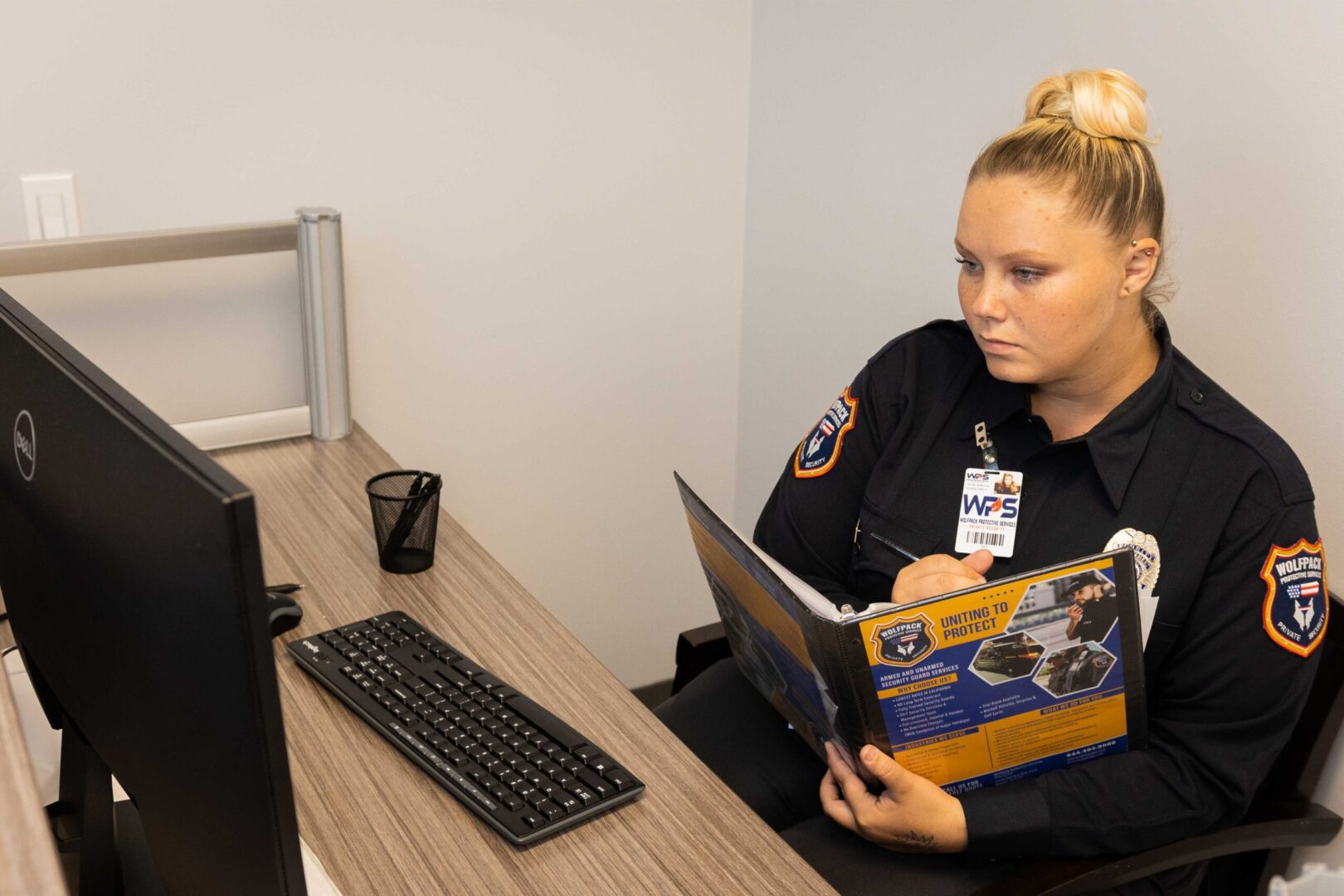 A Police Officer Sitting At Her Desk Reading.
