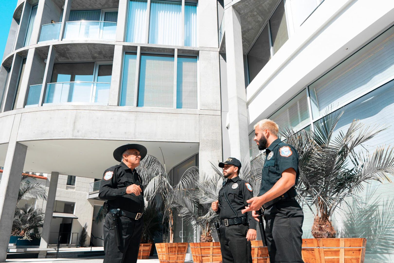 Three police officers standing outside of a building.